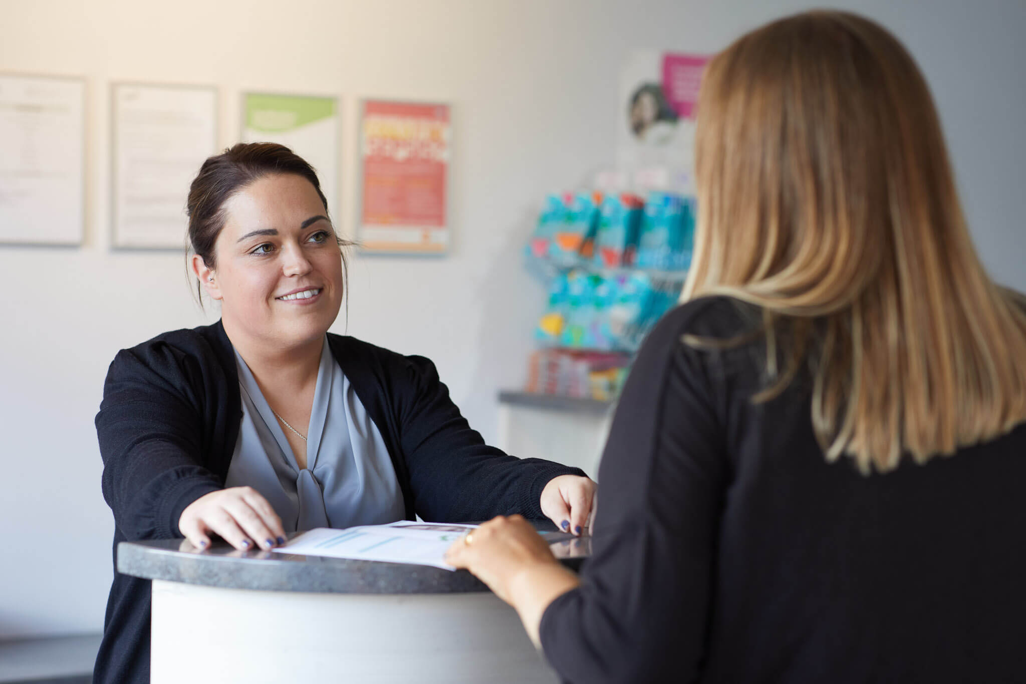 a female receptionist wearing black talking to customer at Boroughbridge Dental's Reception near Ripon